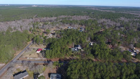 A-drone-shot-traveling-along-a-community-partially-hidden-in-the-woods