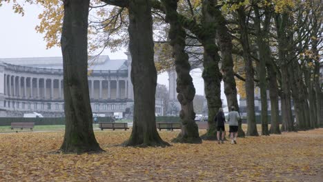 dos ancianos corriendo en jubelpark en cinquantenaire en el centro de la ciudad de bruselas - temporada de otoño