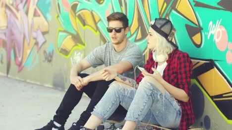 trendy young hipster couple sitting in the street