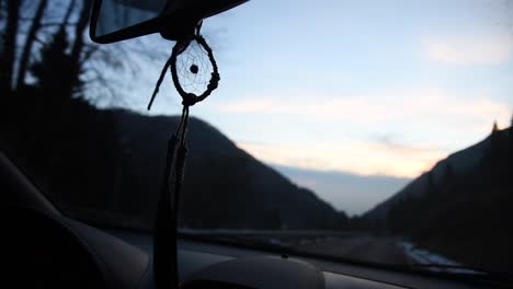 Hermoso-Atrapasueños-Hecho-A-Mano-Moviéndose-Dentro-De-Un-Camión-En-Una-Carretera-De-Montaña-Al-Atardecer