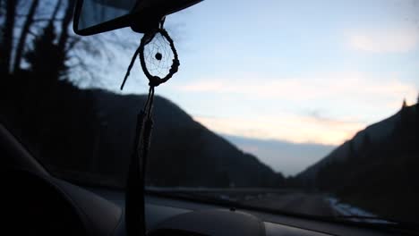 일몰 때 산길에서 차 안에서 움직이는 아름다운 수제 드림캐처