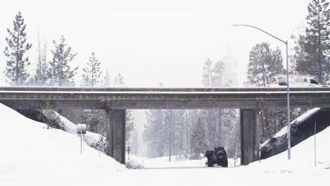 trucks pass over an overpass in the morning as it snows