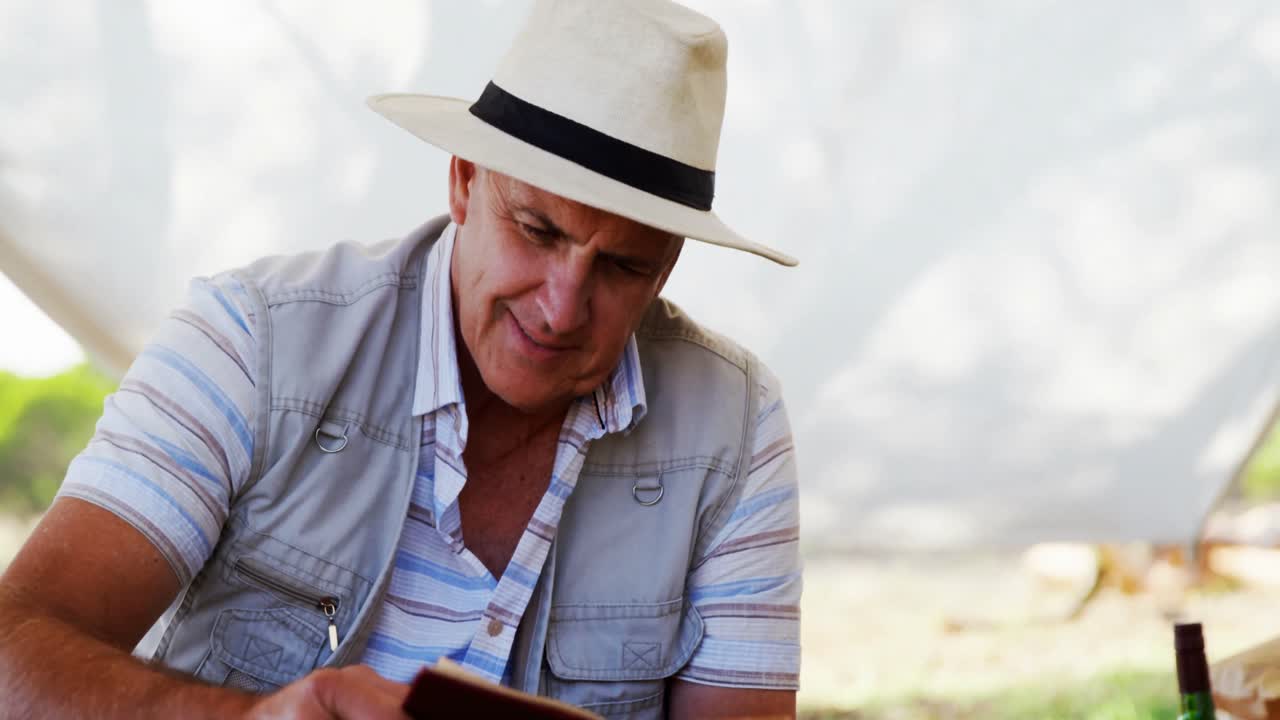 hombre sonriente leyendo un libro en la cabaña 4k