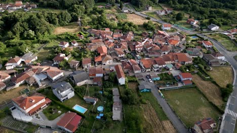 Drone-push-in-tilt-down-above-cute-village-in-countryside-of-europe,-lonoa-spain