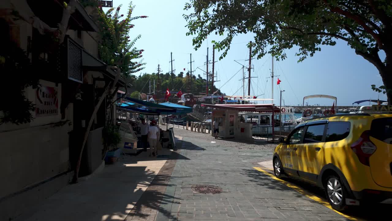 Picturesque Harbor in Turkey: Boats, Shops, and Tourists Enjoying a Sunny Day