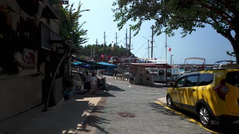 picturesque harbor in turkey: boats, shops, and tourists enjoying a sunny day