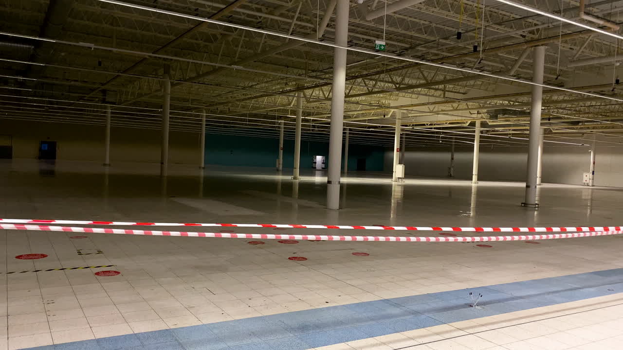 Posto auto interno vuoto chiuso con nastro di barricata rosso e bianco a causa della pandemia di Coronavirus