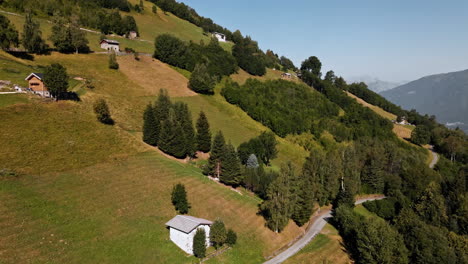 Idyllic-Countryside-Landscape-With-Houses-In-Densely-Green-Mountains-Along-Asphalt-Road-During-Sunny-Summertime-In-Orobie-Alps,-Northern-Italy