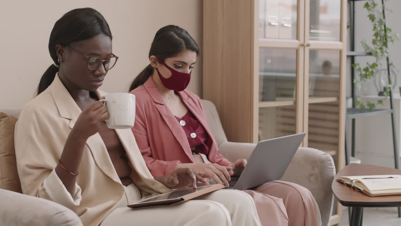 Two Businesswomen Working Together in a Modern Office