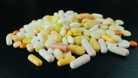 las manos mueven un montón de pastillas y cápsulas