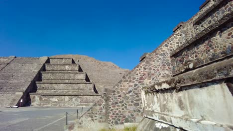 contraste de una diminuta pirámide de teotihuacán ante la majestuosidad de la imponente pirámide del sol