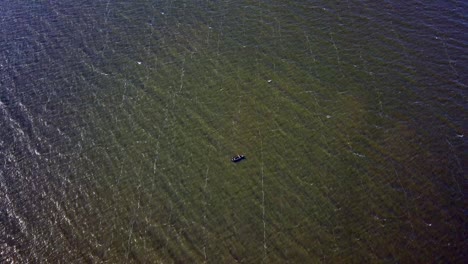 isolated view of a fisherman in a boat on lake victoria, tanzania, africa