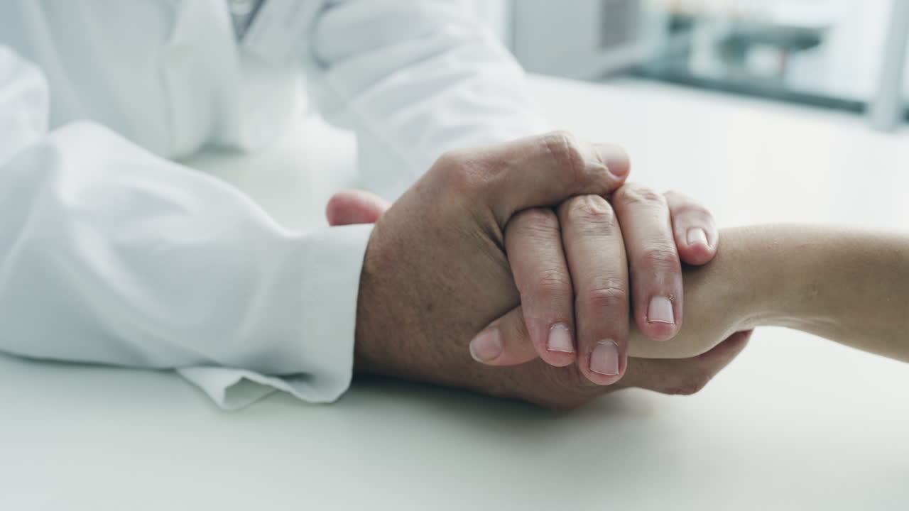 el médico sosteniendo la mano del paciente
