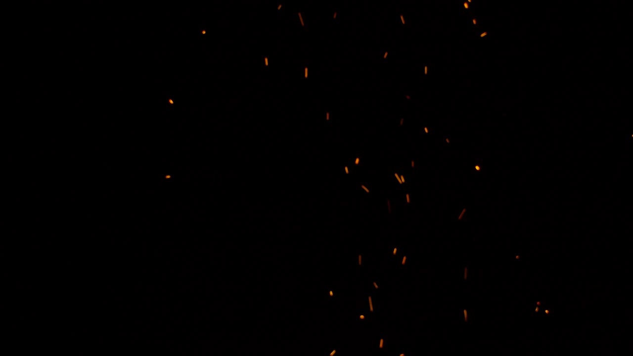 Amazing sparks from a campfire rising against the darkness of the night sky