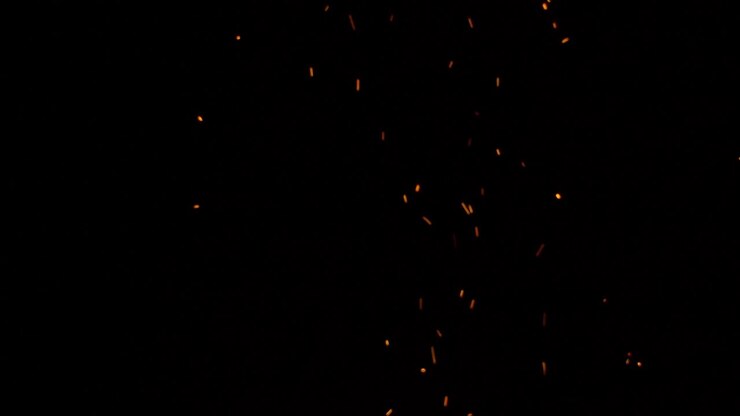 Amazing sparks from a campfire rising against the darkness of the night sky