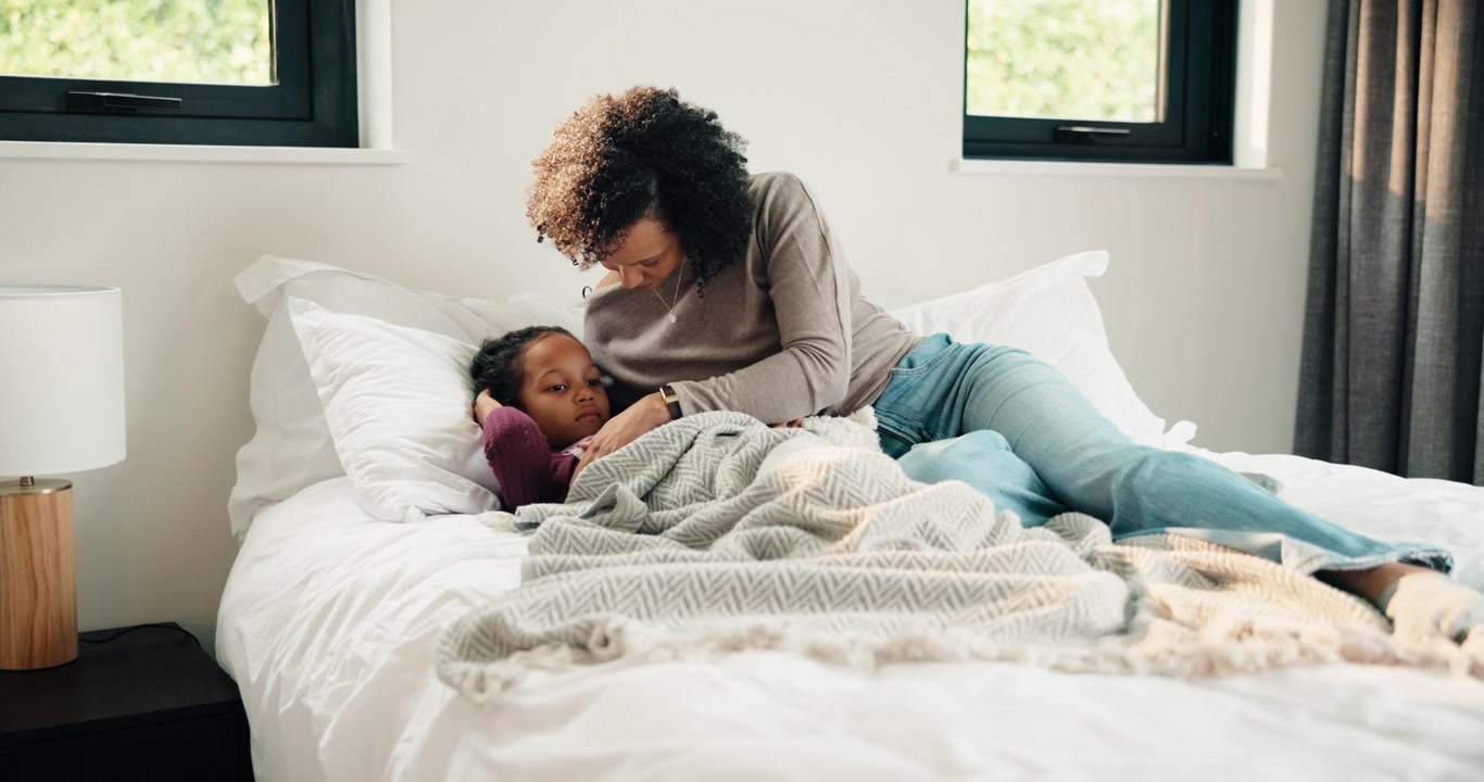 Mother Comforting Her Young Daughter in Bed