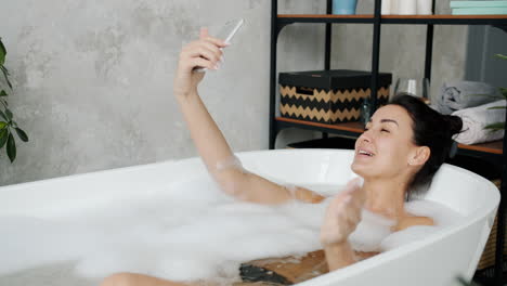 woman taking a selfie in a bubble bath