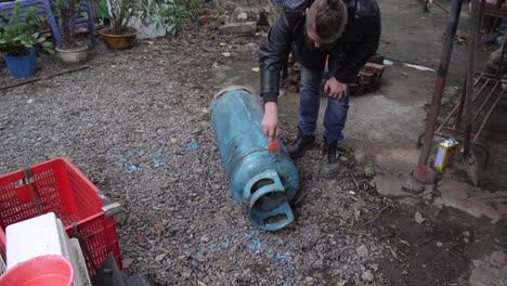 gas tank alteration work undergoing preparation work by adult male