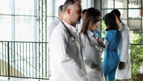 multi-ethnic male and female doctors standing in hospital, talking and looking at x-ray