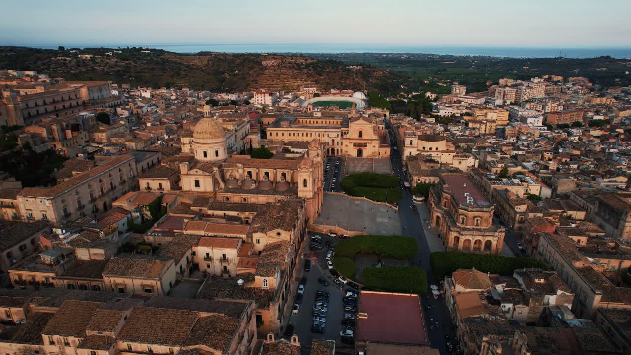 Noto San Nicolò Cathedral and historic buildings during golden evening light. Elegant aerial Sicily