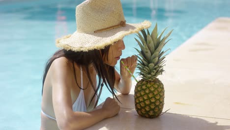 mujer joven bebiendo un cóctel de piña