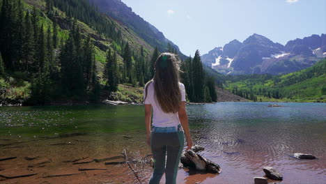 Maroon-Bells-Aspen-Snowmass-wilderness-hike-shoreline-crystal-clear-lake-women-female-model-actress-in-awe-14er-Capital-peaks-Rocky-Mountains-Colorado-summer-stunning-morning-cinematic-follow