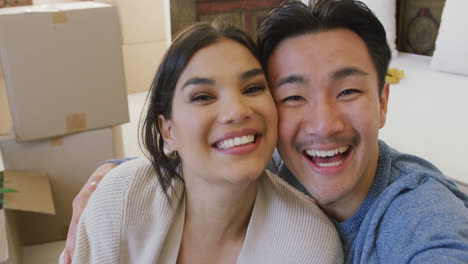 video of happy diverse couple taking selfie in new house