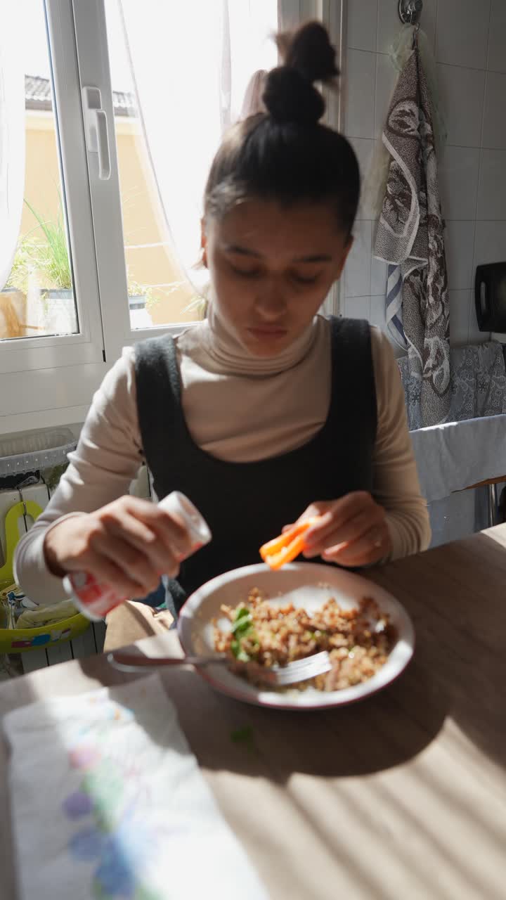 mujer comiendo una comida en una cocina