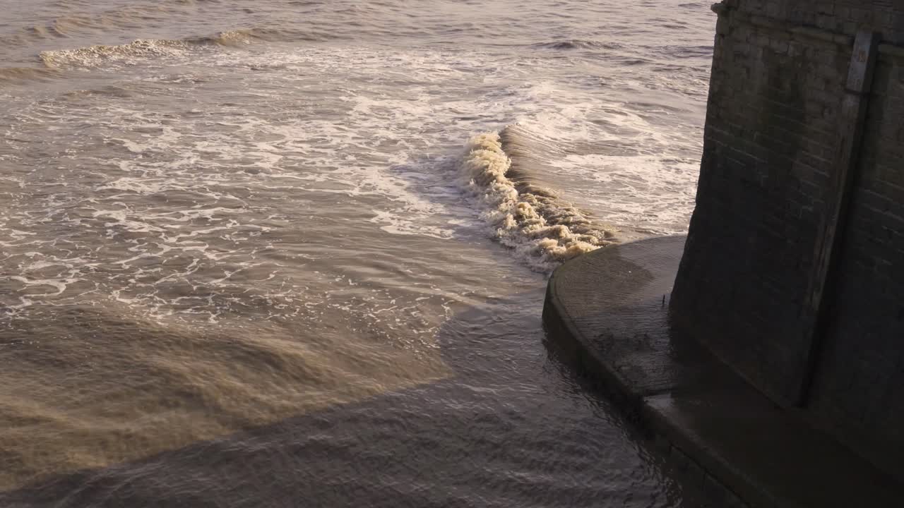 WESTON SUPER MARE, SOMERSET, UNITED KINGDOM, December 23, 2019: Polluted water waves crushing on the old pier of Weston .