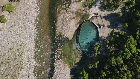 aerial view looking directly at the turquoise water with some people enjoying themselves in benja's hot springs