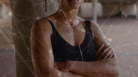 Network-of-connections-against-portrait-of-african-american-fit-woman-wearing-earphones