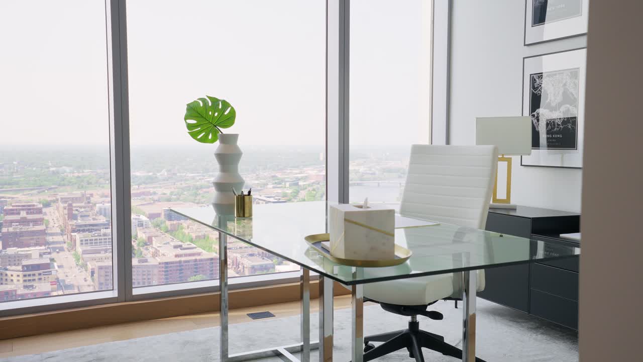 Push in shot of a bright office space in a high-rise apartment, featuring large windows that flood the area with abundant natural light with a glass table and a white office chair