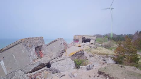 aerial view of abandoned seaside fortification buildings at karosta northern forts on the beach of baltic sea in liepaja, latvia, calm sea on a sunny day, wide low angle drone shot moving backward