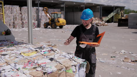 manager checks quality of the bound pressed paper bale coming out of machine