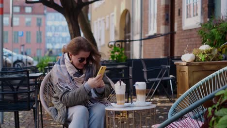 woman enjoying a latte in a cozy outdoor cafe