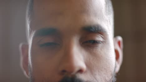 portrait close up of focused biracial man opening eyes and looking to camera in slow motion