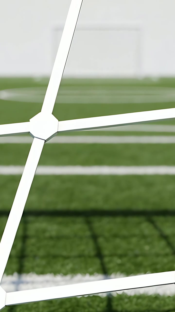 Video verticale: Telecamera in panoramica che mostra una rete da calcio bianca sul campo, rivelando la cornice della porta e le linee sfocate.