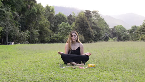 yoga girl closes her eyes and meditates in lotus flower pose in the park