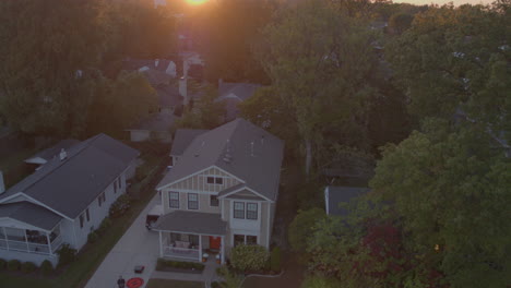 descent towards house in suburbia with drone op in driveway at sunset