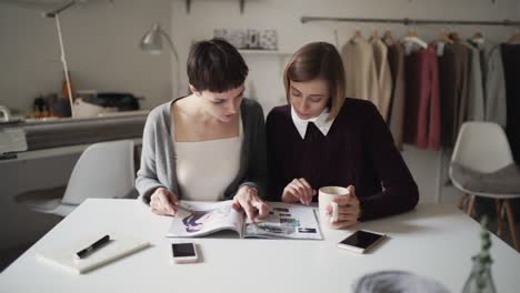 two sisters together reading woman magazine. woman looking fashion magazine