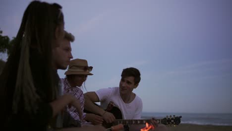 picnic of young people with bonfire on the beach in the evening 2