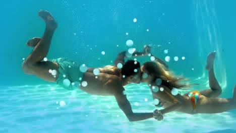 young couple kissing each other underwater with light effects