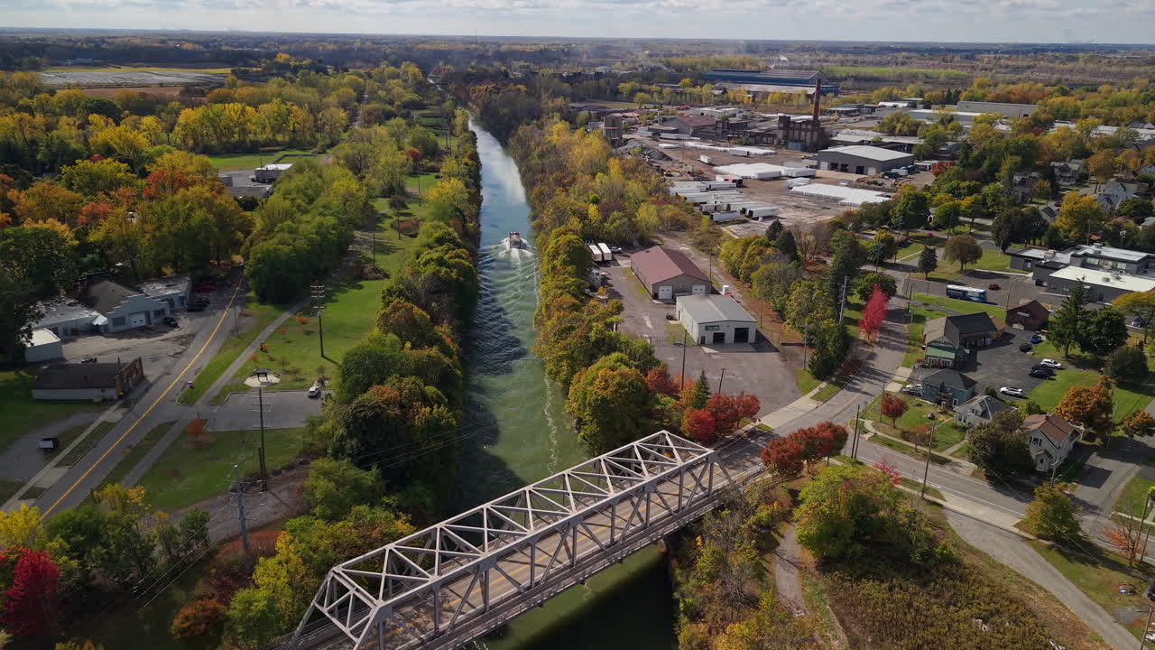 Veduta aerea del ponte del Canale Erie a Lockport, New York, USA, con paesaggio autunnale, distretto industriale e scia di barca