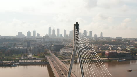 Fliegen-Sie-Um-Die-Hohe-Moderne-Schrägseilbrücke-Swietokrzyski-über-Die-Weichsel-Herum.-Silhouette-Des-Panoramas-Der-Wolkenkratzer-In-Der-Innenstadt.-Warschau,-Polen