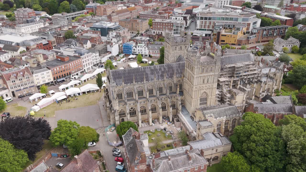 풍부한 초록색으로 둘러싸인 세터 대성당 (exeter cathedral) 의 복잡한 건축물을 보여주는 드론 도 뷰 (drone orbital view)
