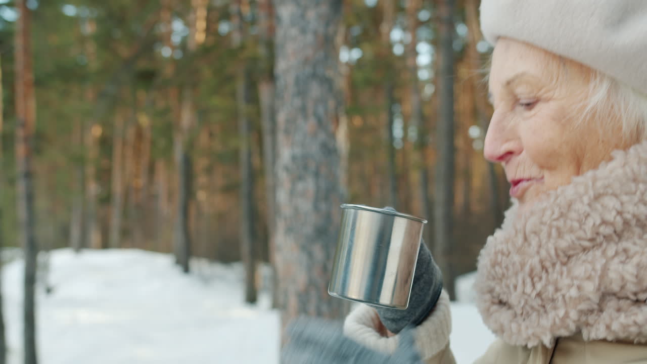 Elderly women enjoying warm drinks in a snowy forest