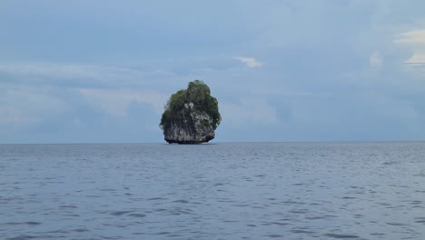 Alleinstehender-Kalksteinfelsen-Im-Tropischen-Meerwasser,-Blick-Vom-Schnell-Fahrenden-Boot