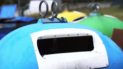 man’s hand throwing cardboard into recycling bin