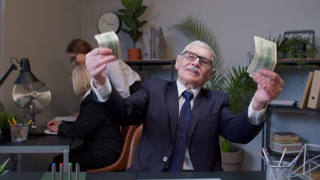 cheerful senior business company manager celebrating business success dancing with money dollar cash