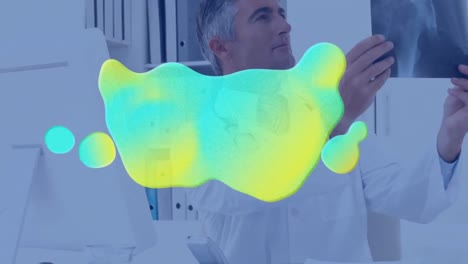 animación de mancha azul y amarilla sobre el médico usando computadora